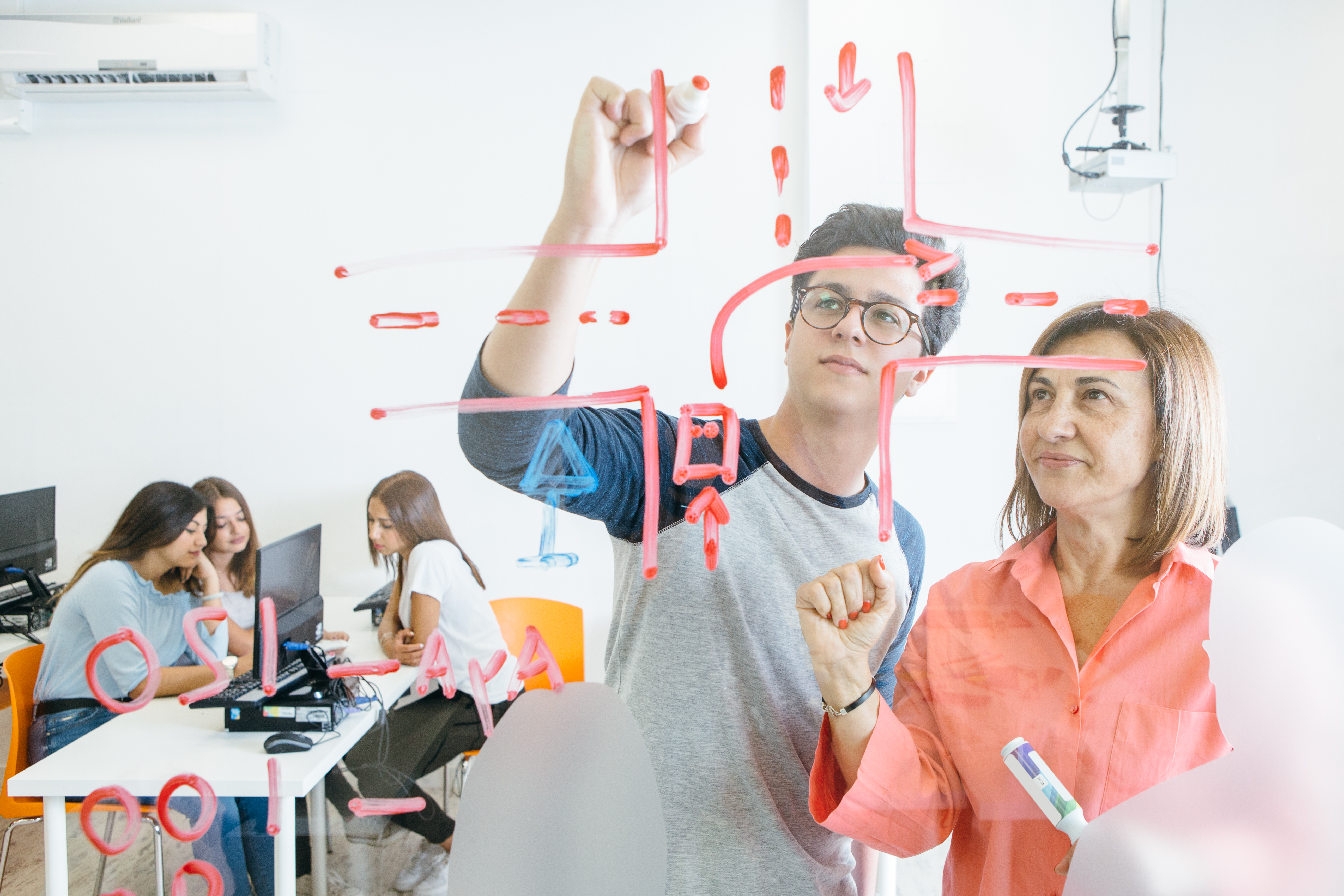 Student and teacher drawing on board
